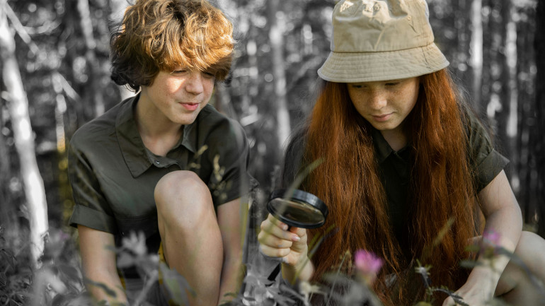 Enfants qui observent la nature avec une loupe